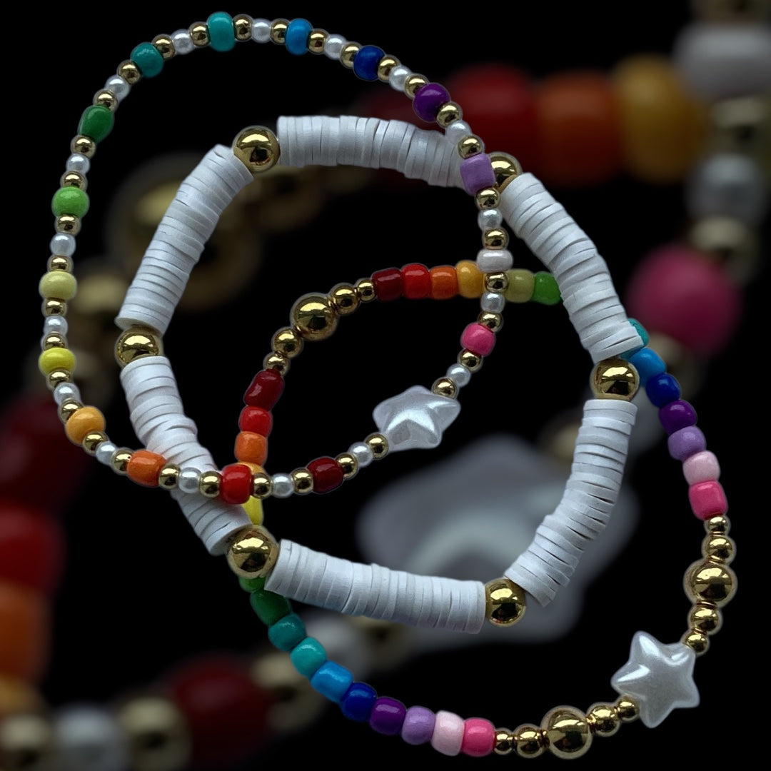 Twinkle Pop bracelet stack – white, rainbow and gold beaded set
Handmade stretch bracelet set with stars and colourful seed beads
Bright 3-piece bracelet stack with gold spacers and polymer discs
Rainbow beaded bracelets with pearl-look stars – Twinkle Pop
Playful handmade bracelet trio with dreamy gold and rainbow tones