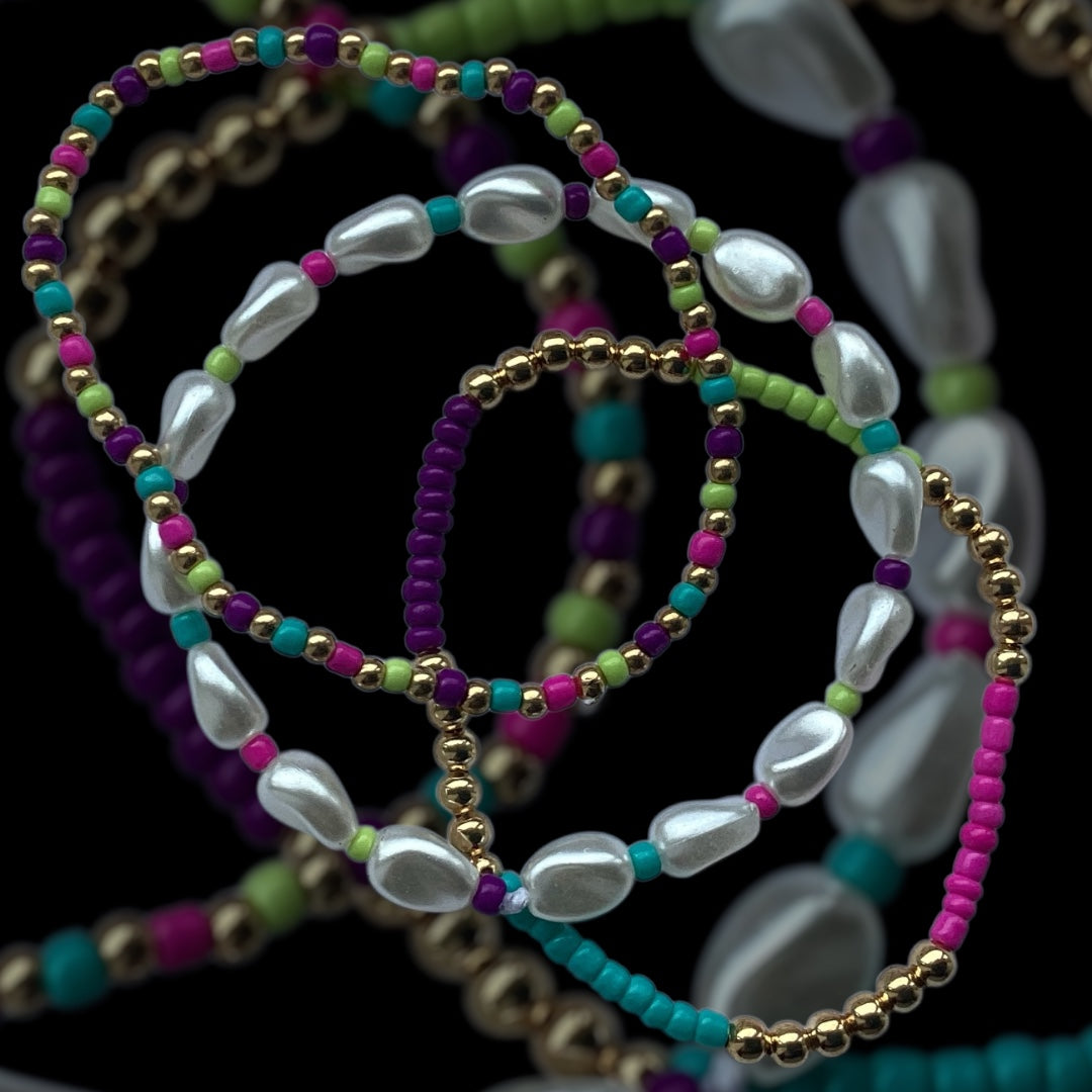 Tropic Pearl bracelet stack – pearl drop beads with teal, pink, and purple
Bright handmade bracelet trio with gold and tropical seed beads
Tropical-inspired beaded bracelet stack – Tropic Pearl by Pxl Nate
3-piece bracelet set with pearl-look beads and vibrant tones
Handmade stretch bracelet set with gold accents – UK made