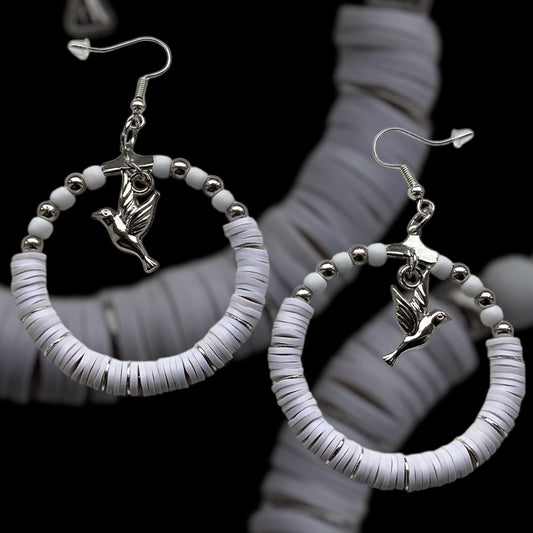 Silver Tone:
White handmade hoop earrings with silver-tone beads and a dangling bird charm, crafted from polymer clay with silver accent slices, minimalist lightweight jewellery on black background