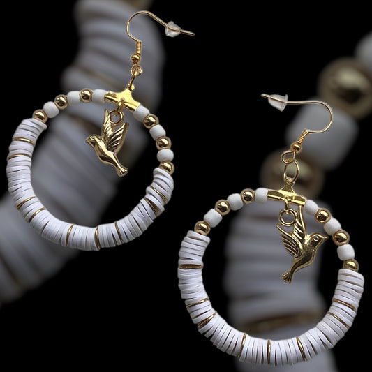 Gold Tone:
White handmade hoop earrings with gold-tone beads and a dangling bird charm, crafted from polymer clay with gold accent slices, elegant lightweight jewellery on black background
